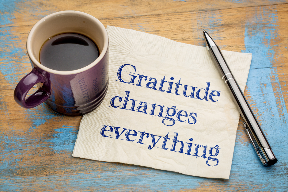 A coffee mug beside a napkin with the handwritten message 'Gratitude changes everything,' highlighting the importance of practicing gratitude daily.